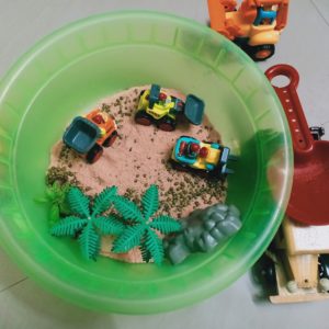 A bin containing biscuit crumbs for play.